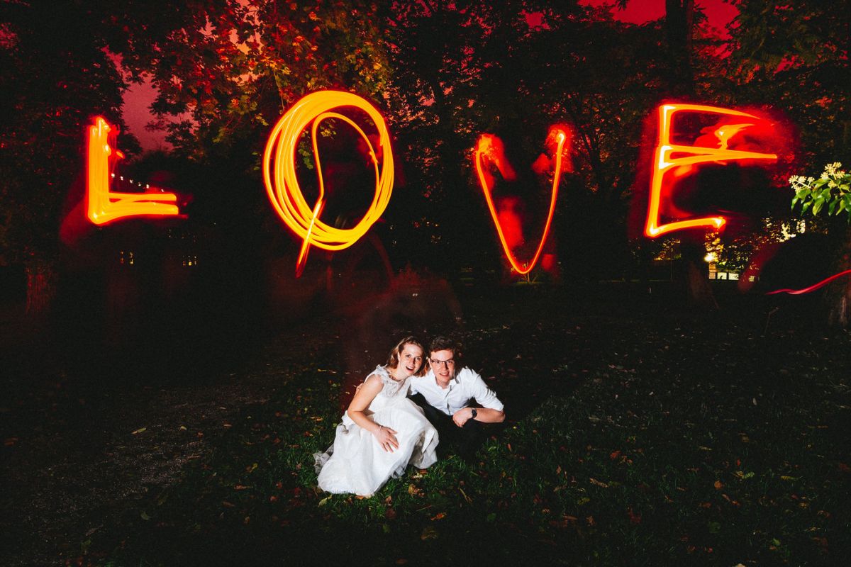 Wedding photo with Lightpainting in the park of the Juliusspital, couple with lightpainted "Love" in the background - Wedding Photographer Wuerzburg BRAUTRAUSCH®
