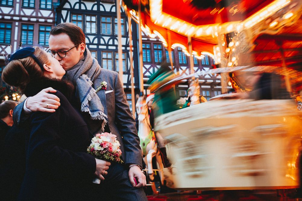 Winterhochzeit in Frankfurt - Küssendes Paar auf dem Weihnachtsmarkt kurz nach ihrer standesamtlichen Trauung im Römer