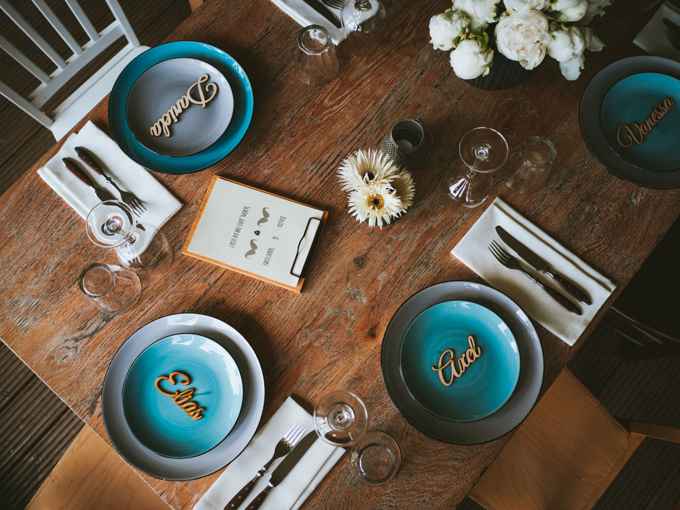 Tischdeko im Blaues Wasser mit Blumen und türkisfarbenen Tellern