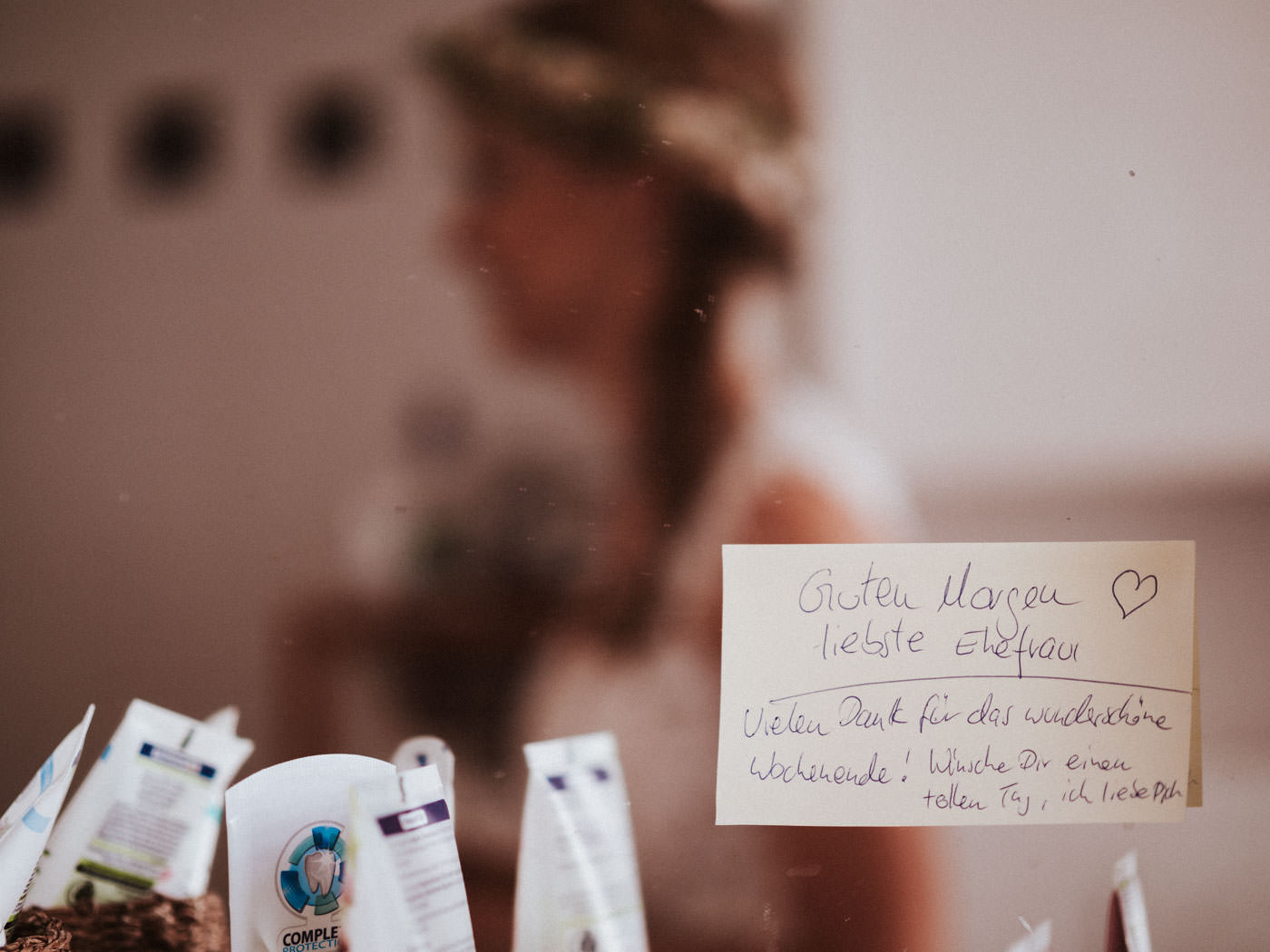 Nachricht vom Bräutigam auf einem PostIt am Spiegel im Bad, Braut ist im Spiegel unscharf zu erkennen - kurz vor der Hochzeit auf Weingut Weidenmühle