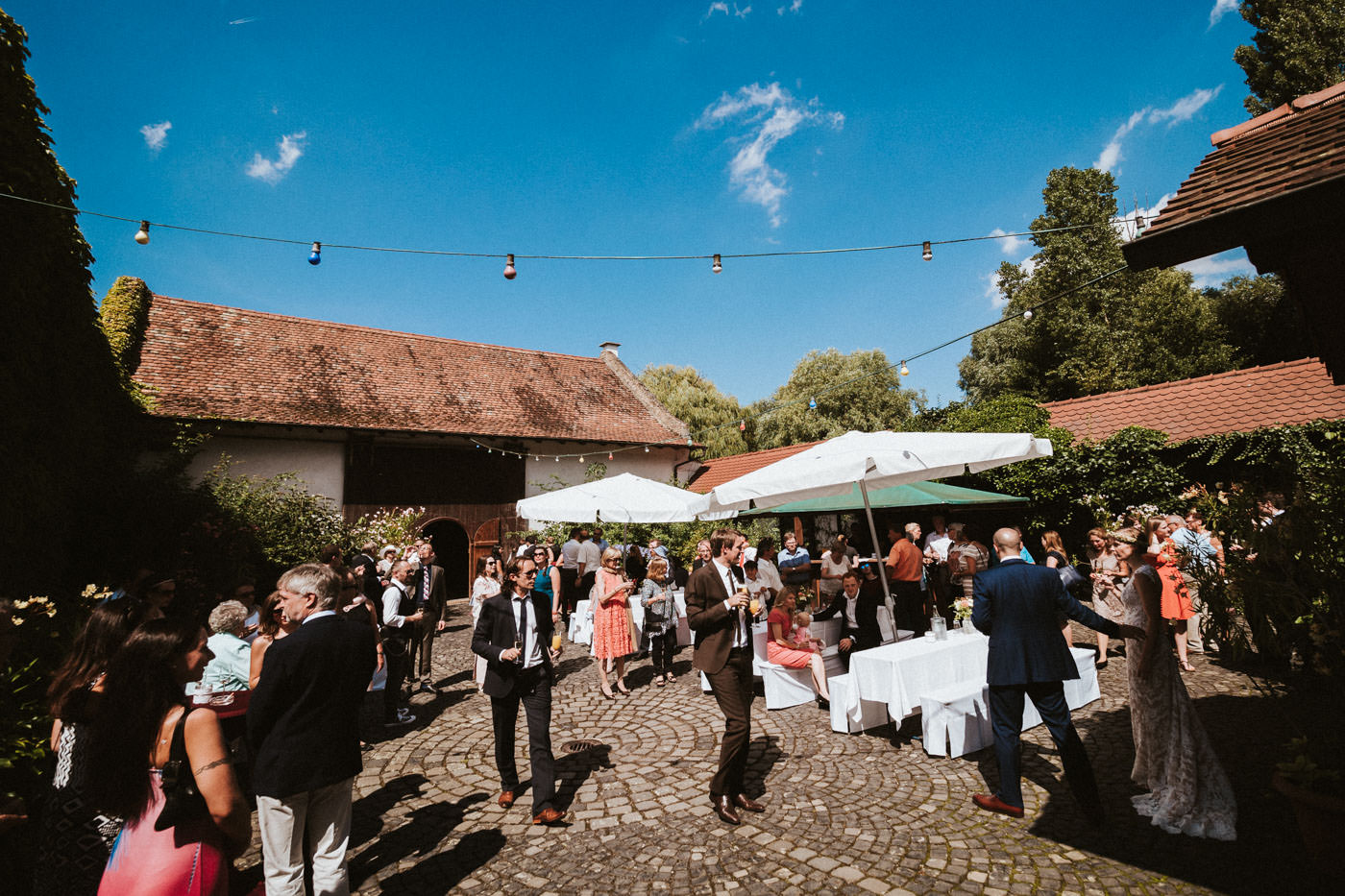 Relaxed atmosphere during a wedding reception in the courtyard of Weidenmühle winery