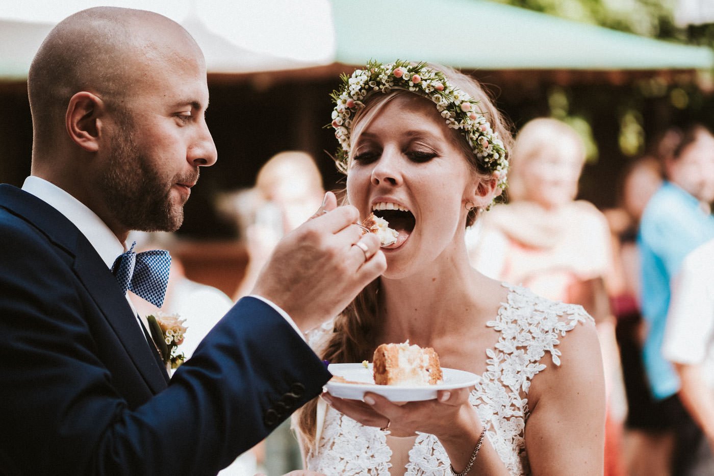 Groom feeds bride with wedding cake