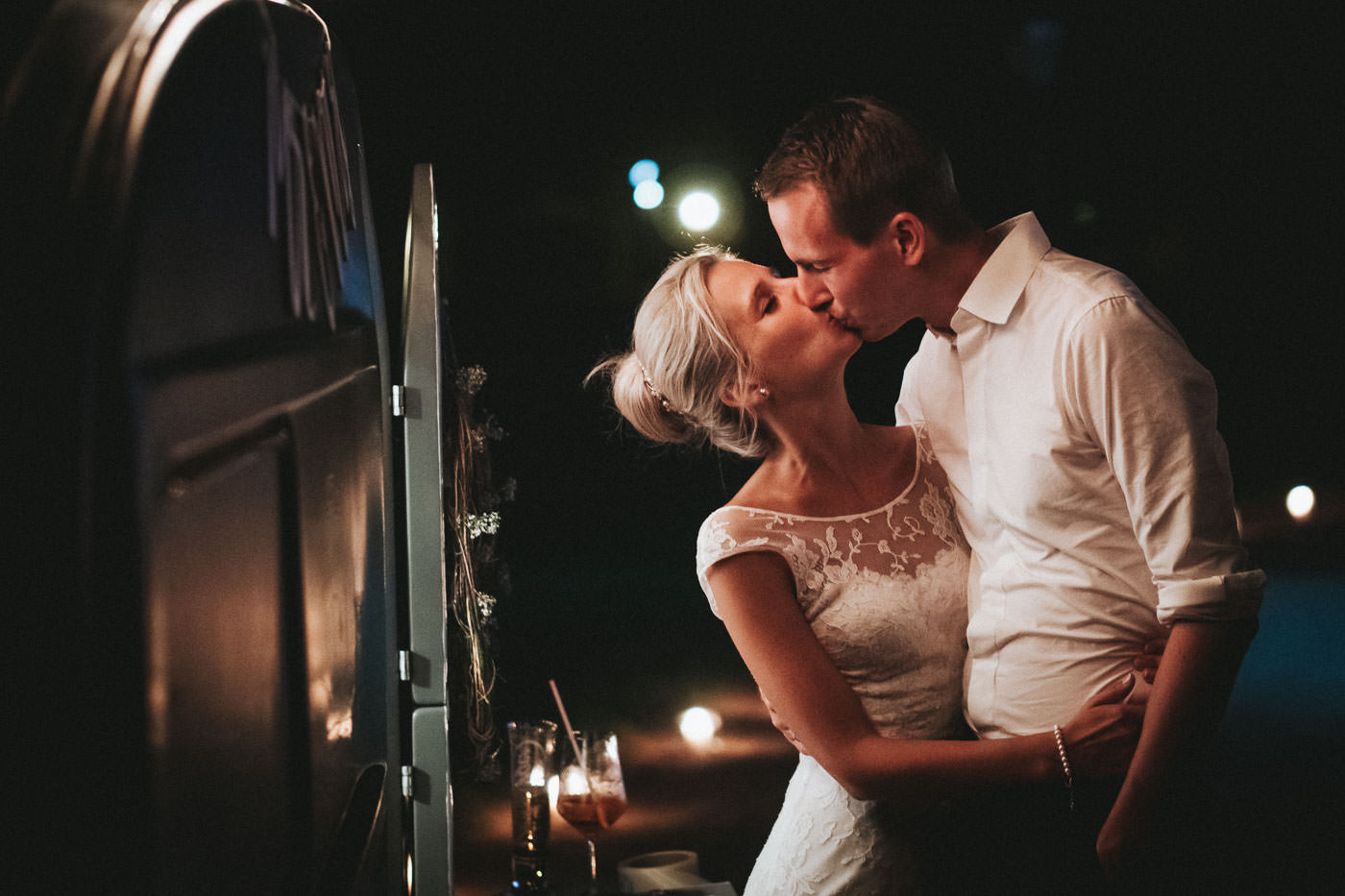 Brautpaar küsst sich vor einem alten Camper, Nachtaufnahme einer Hochzeit in Bad Homburg