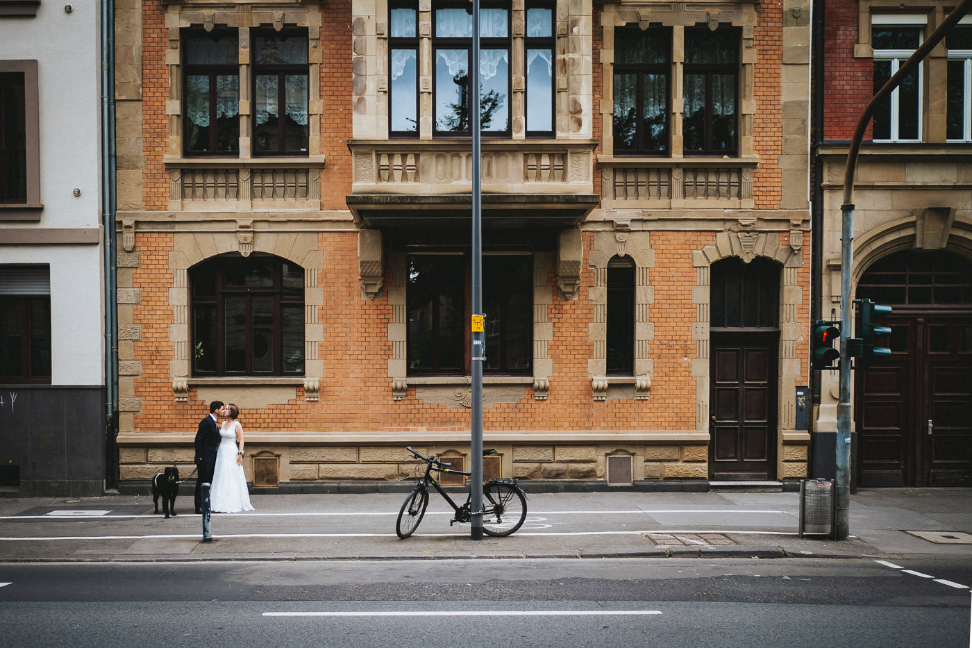 Brautpaar beim Spaziergang in der Mainzer Innenstand, küssend am Straßenrand mit Hund und Fahrrad - Hochzeitsfotograf Mainz, Brautrausch