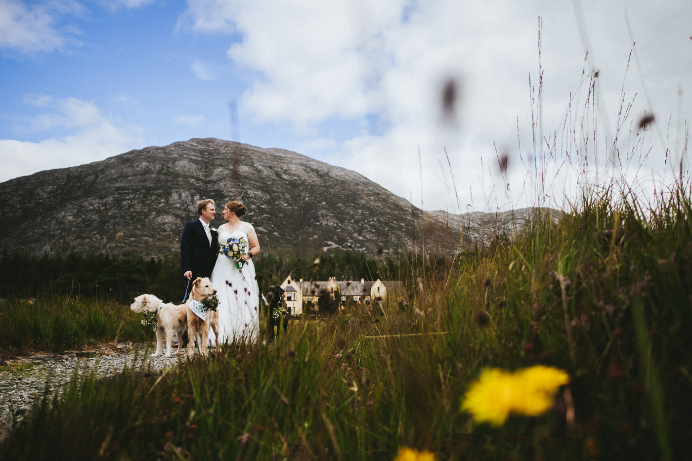 Heiraten in Irland, Brautpaar am Lough Inagh in Connemara, mit Lough Inagh Lodge und Bergen im Hintergrund - Hochzeitsfotograf Irland Brautrausch