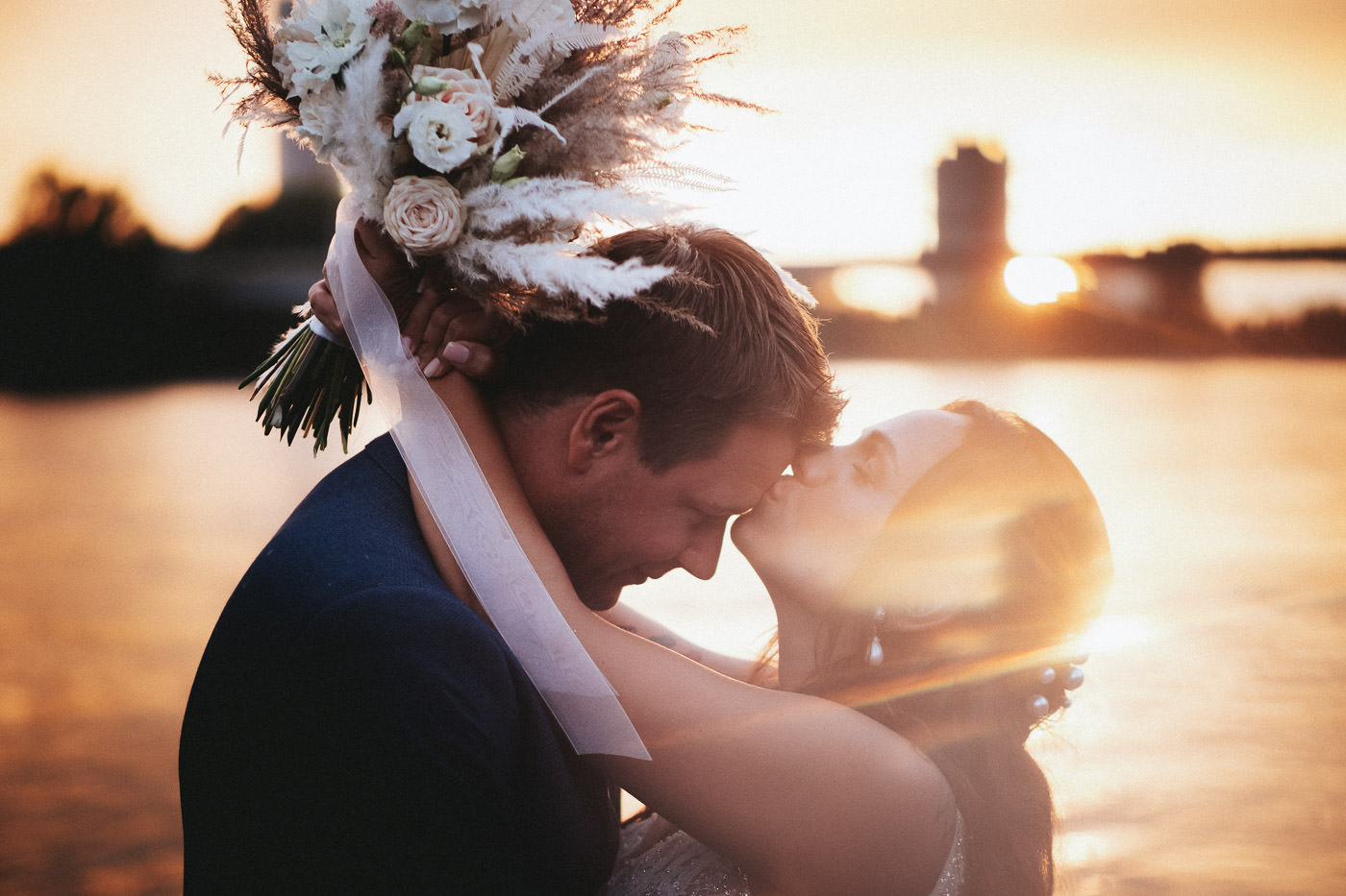 Nahaufnahme von küssendem Brautpaar auf dem Anleger am Bonner Rheinufer - Hochzeitsfotograf Rheinland, Brautrausch