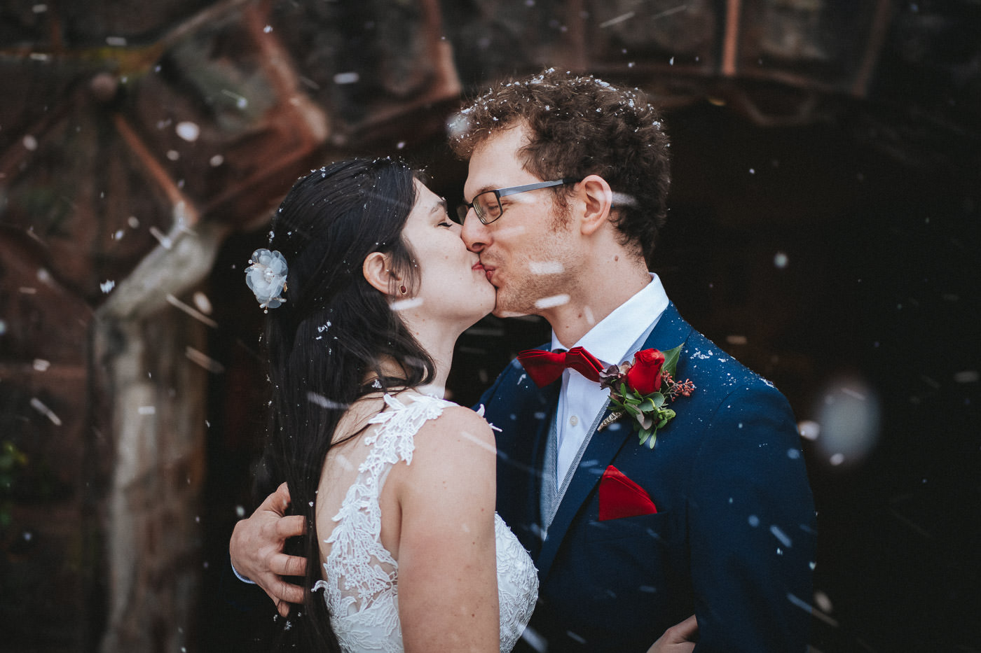 Küssendes Brautpaar beim First Look im Schneetreiben vor Schloss Saareck in Mettlach, Winterhochzeit im Saarland - Hochzeitsfotograf Deutschland, Brautrausch