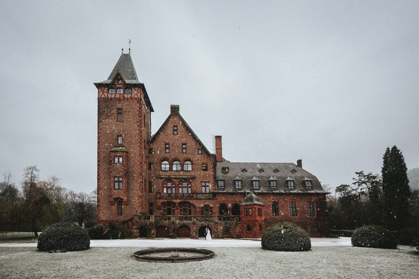 Brautpaar First Look im Schneetreiben vor Schloss Saareck in Mettlach, Winterhochzeit im Saarland - Hochzeitsfotograf Deutschland, Brautrausch