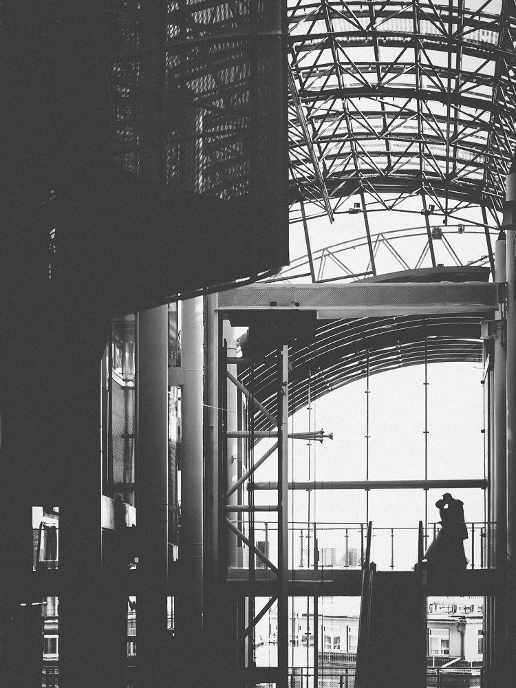 Brautpaar steht küssend auf Balkon in Frankfurter Shoppingcenter auf der Zeil - Hochzeitsfotograf Frankfurt Brautrausch