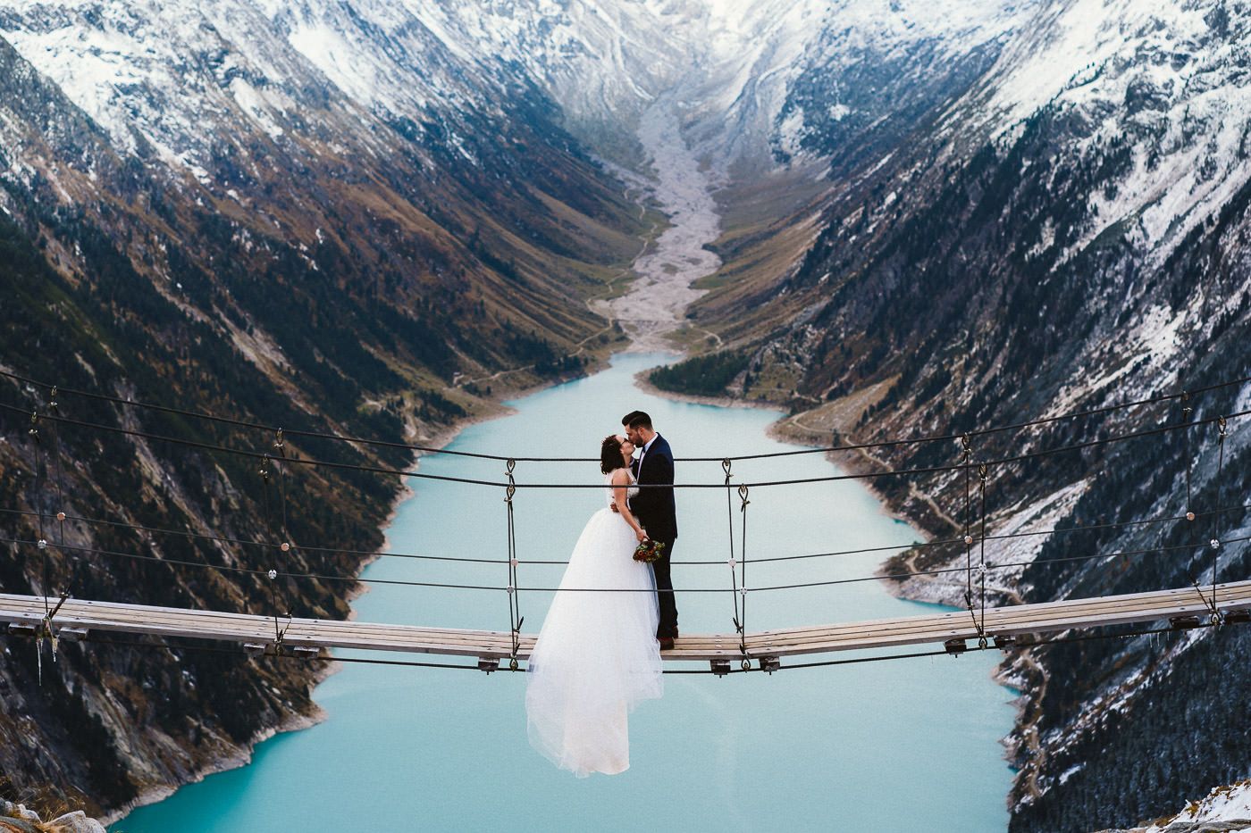 Brautpaar auf der Hängebrücke an der Olpererhütte im Zillertal, küssend vor dem Hintergrund des Schlegeisspeichers