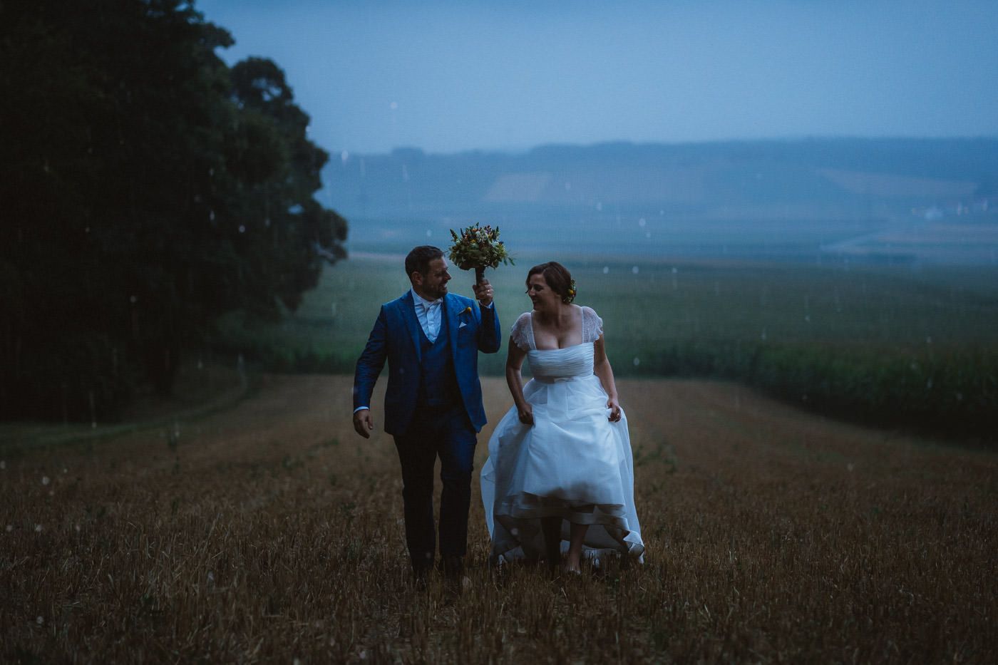 bridal couple in the pouring rain - rainy day wedding photos