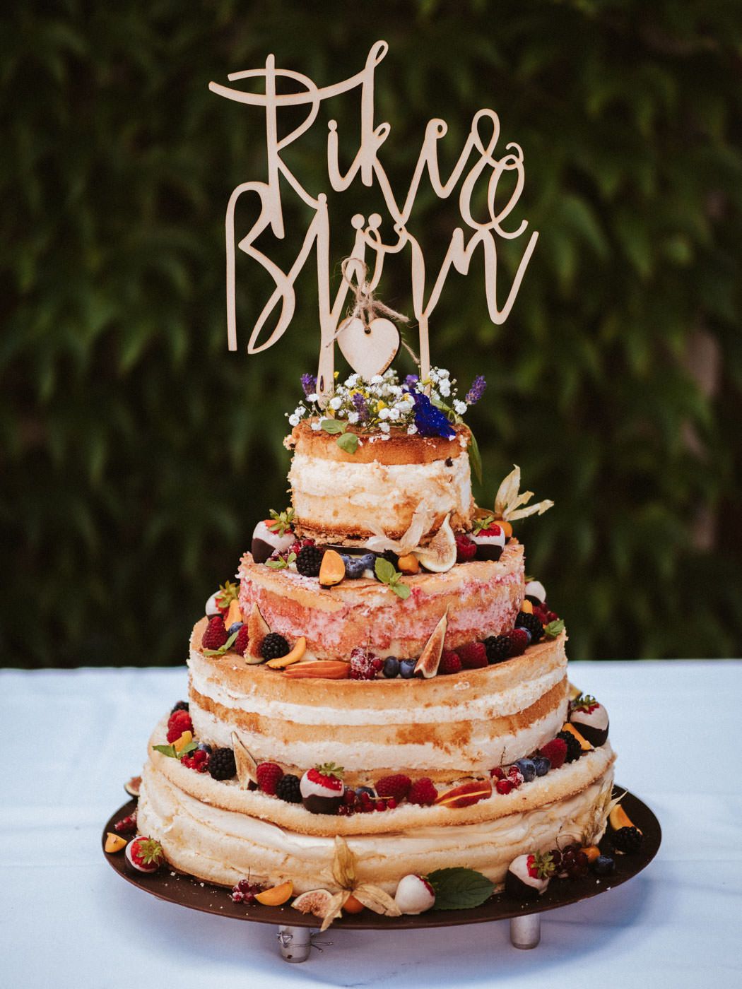 Naked Cake Hochzeitstorte mit Obst und Blumen auf einer Hochzeit im Weingut Weidenmühle