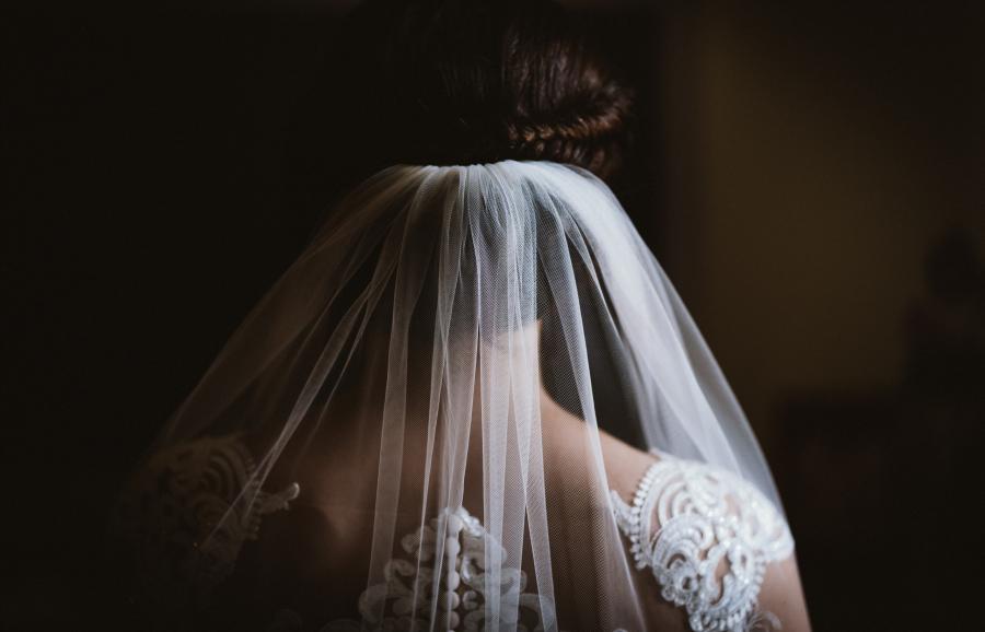 Bride from behind - dramatic side light sets the veil centre stage