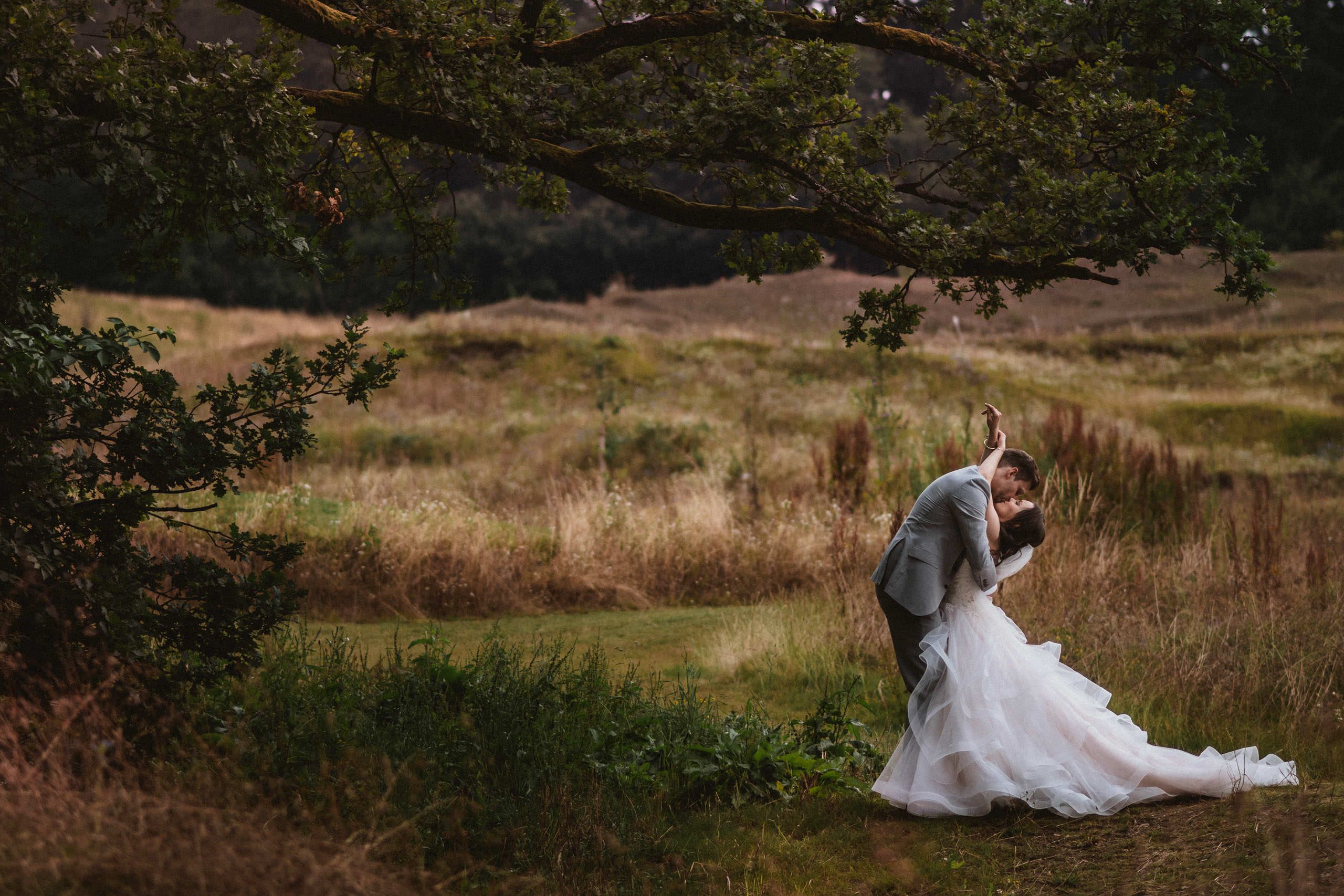Brautpaar küssend unter Baum am Waldrand - Hochzeitsfotograf Taunus Brautrausch