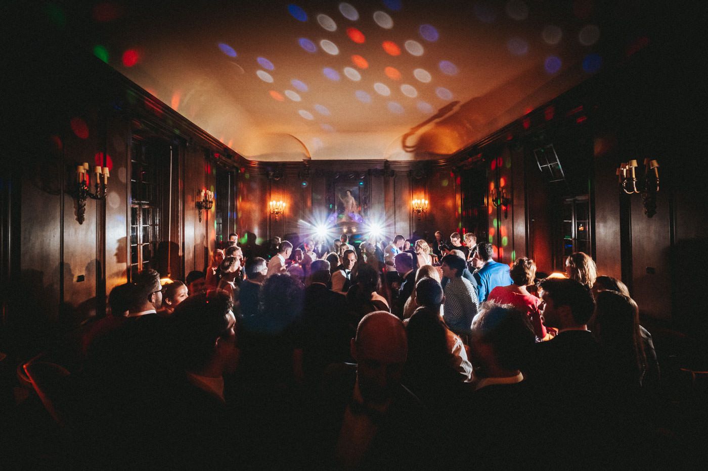 Partymood in the winter salon of Saareck Castle, Bridal Couple and guests dancing, backlight by flashes and partylighting