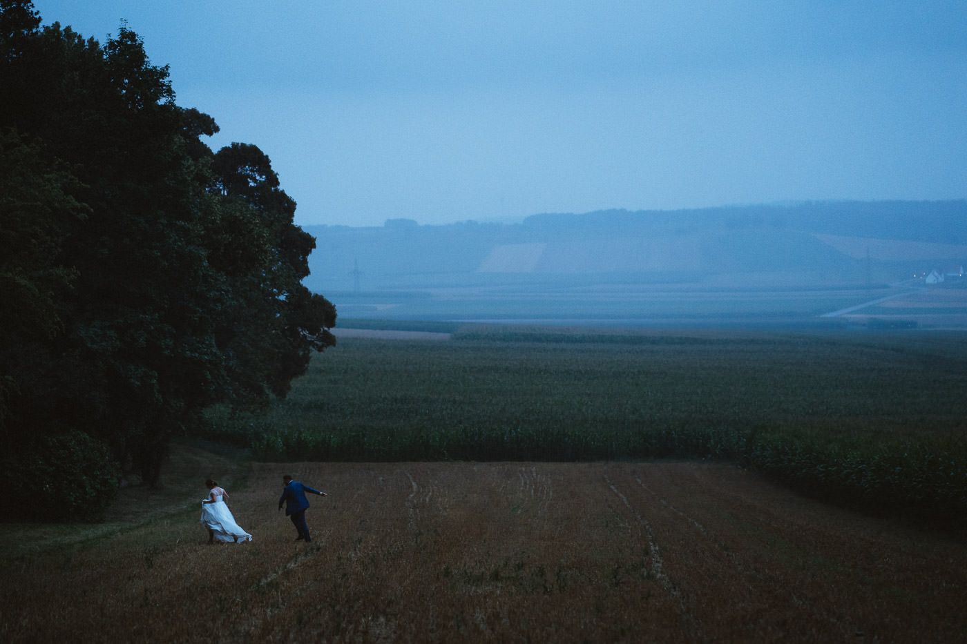 bridal couple in the rain with a lot of landscape