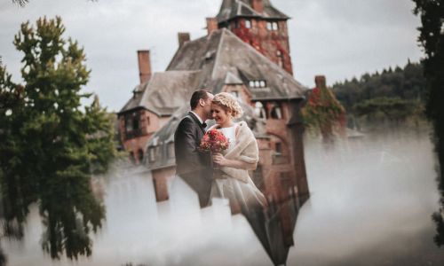 Hochzeit auf Schloss Saareck, Hochzeitsfotos in Mettlach, Vorschaubild mit Brautpaar vor Schloss