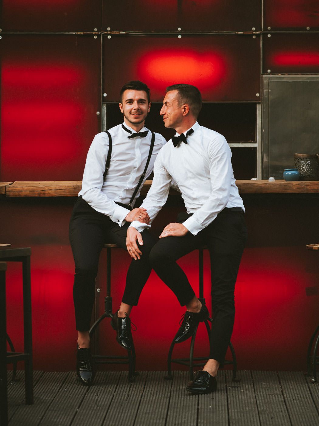 Two freshly married men sitting on the bar