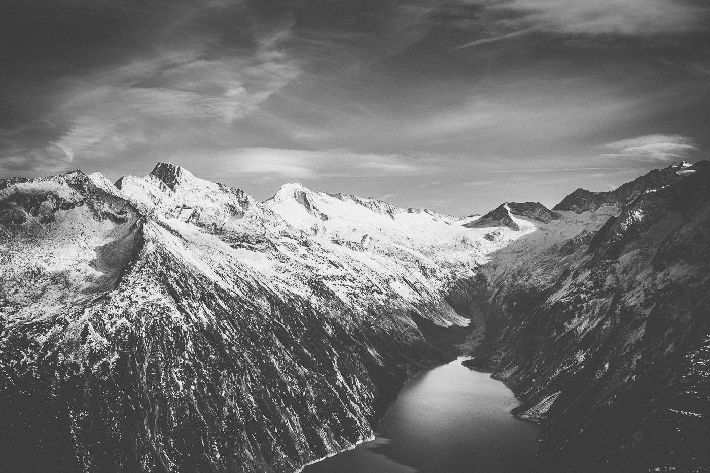 Schwarzweissfoto mit Blick von der Olpererhütte auf den schneebedeckten Zillertaler Kamm mit Schlegeisspeicher im Vordergrund