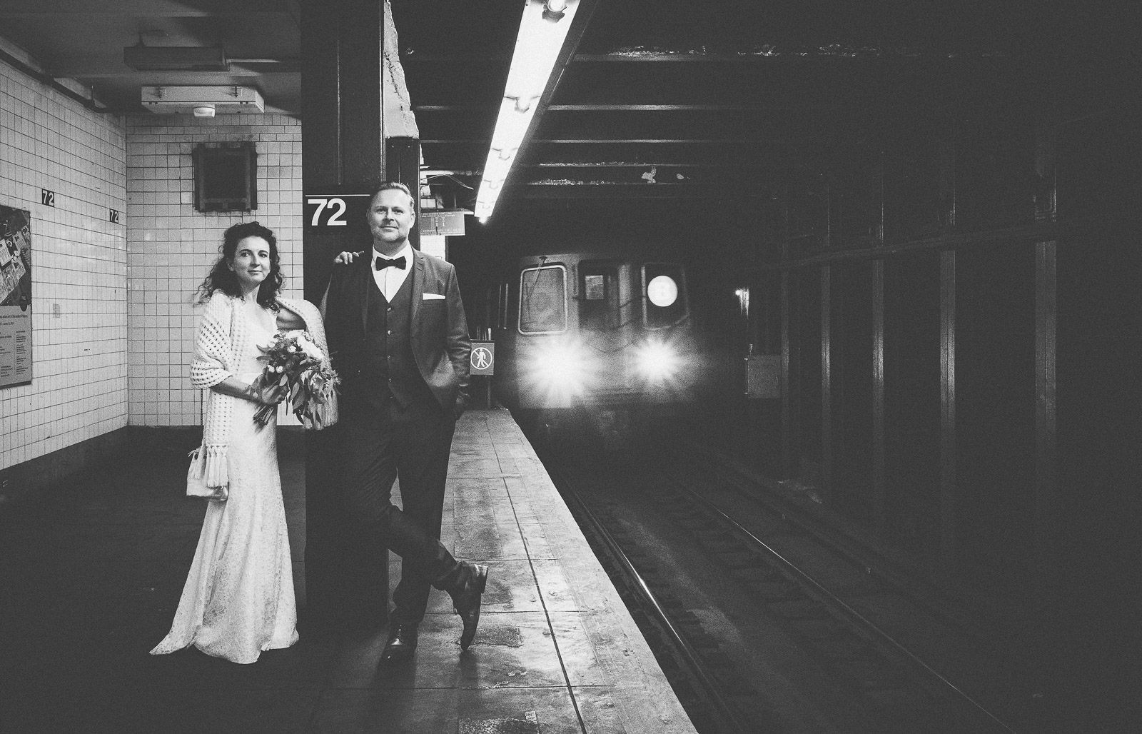 Hochzeitspaar in der New Yorker Subway vor den Lichtern eines einfahrenden Zuges - Elopement in New York