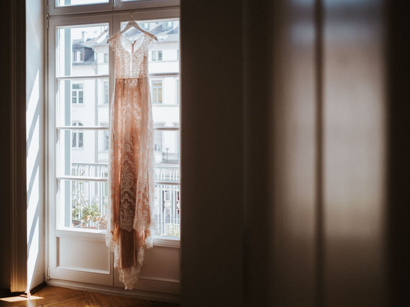 Boho Vintage Brautkleid am Fenster einer Altbauwohnung