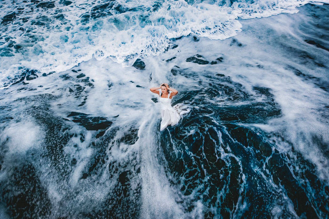 Braut in der Brandung des Atlantik, Vogelperspektive zeigt tolle Muster in der Wasseroberfläche, After-Wedding-Session am Slea Head, Dingle, Co. Kerry, Irland